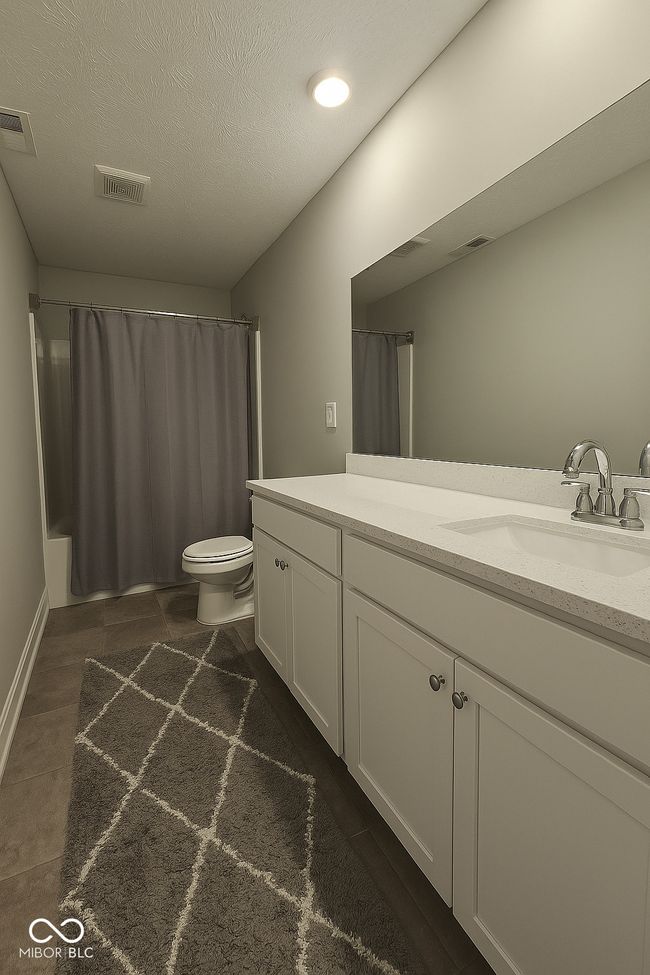 bathroom with vanity, toilet, tile patterned floors, shower / bath combination with curtain, and a textured ceiling | Image 19