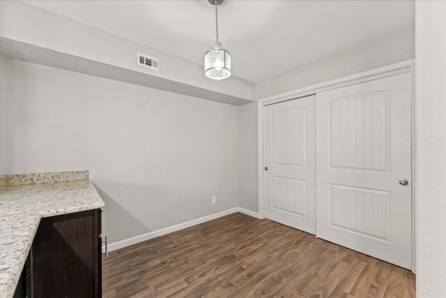 Unfurnished dining area with dark wood-style floors and baseboards | Image 10