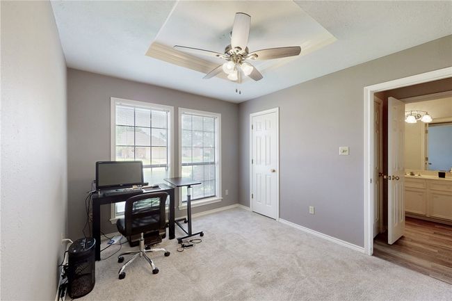 Office featuring baseboards, light colored carpet, ceiling fan, and a raised ceiling | Image 19