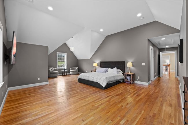 Bedroom with baseboards, vaulted ceiling, light wood-type flooring, recessed lighting, and attic access | Image 25