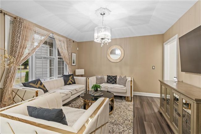 Living room with a tray ceiling, dark wood-style floors, and plenty of natural light | Image 13