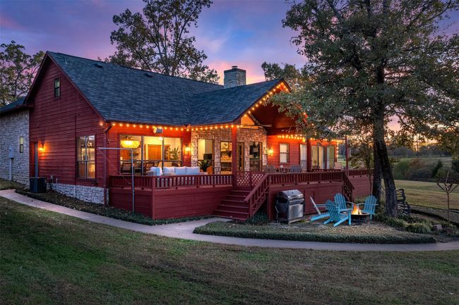 Back house at dusk with a wooden deck, a yard, and an outdoor hangout area | Image 32