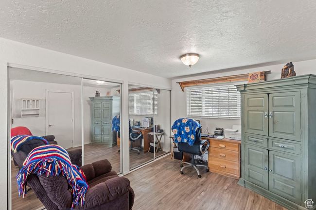 Home office with a textured ceiling and light wood finished floors | Image 14