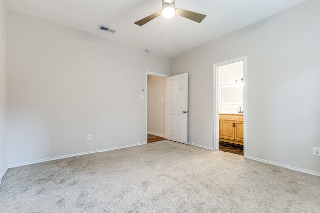 Unfurnished bedroom with carpet flooring, ensuite bathroom, and a ceiling fan | Image 10