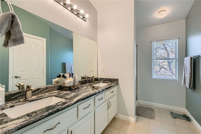 Bathroom featuring double vanity, a sink, and baseboards | Image 14