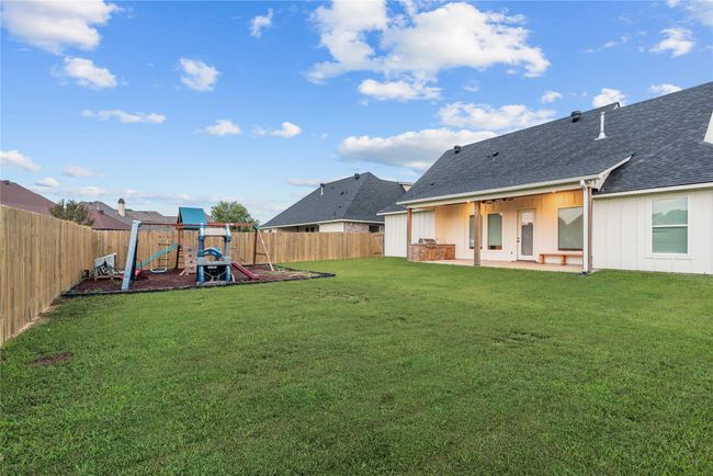 Fenced backyard with a patio area and a playground | Image 29