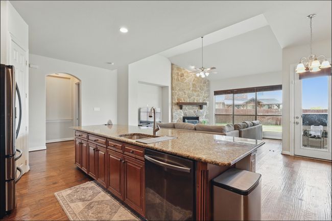 Kitchen with black microwave, arched walkways, stainless steel fridge with ice dispenser, a kitchen bar, and recessed lighting | Image 14