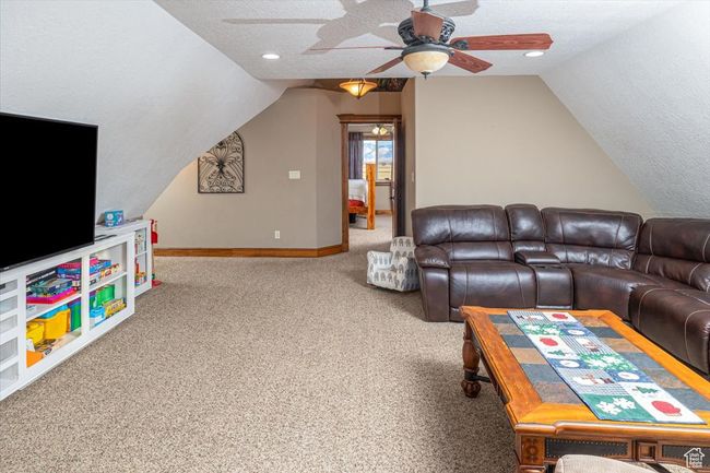Living room with ceiling fan, lofted ceiling, carpet flooring, and a textured ceiling | Image 28