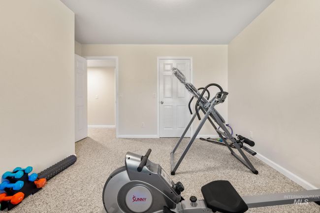 Lower level 4th bedroom currently used as a Workout room with carpet floors and baseboards | Image 36