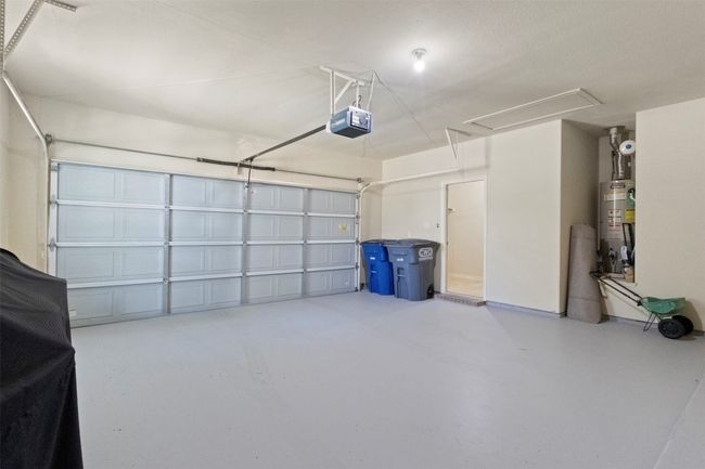 Garage featuring a garage door opener and gas water heater | Image 21