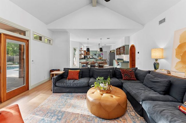 Living area with light wood-type flooring, ceiling fan, high vaulted ceiling, and arched walkways | Image 11