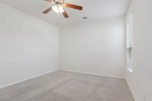 Carpeted spare room featuring visible vents, a ceiling fan, baseboards, and a healthy amount of sunlight | Image 22