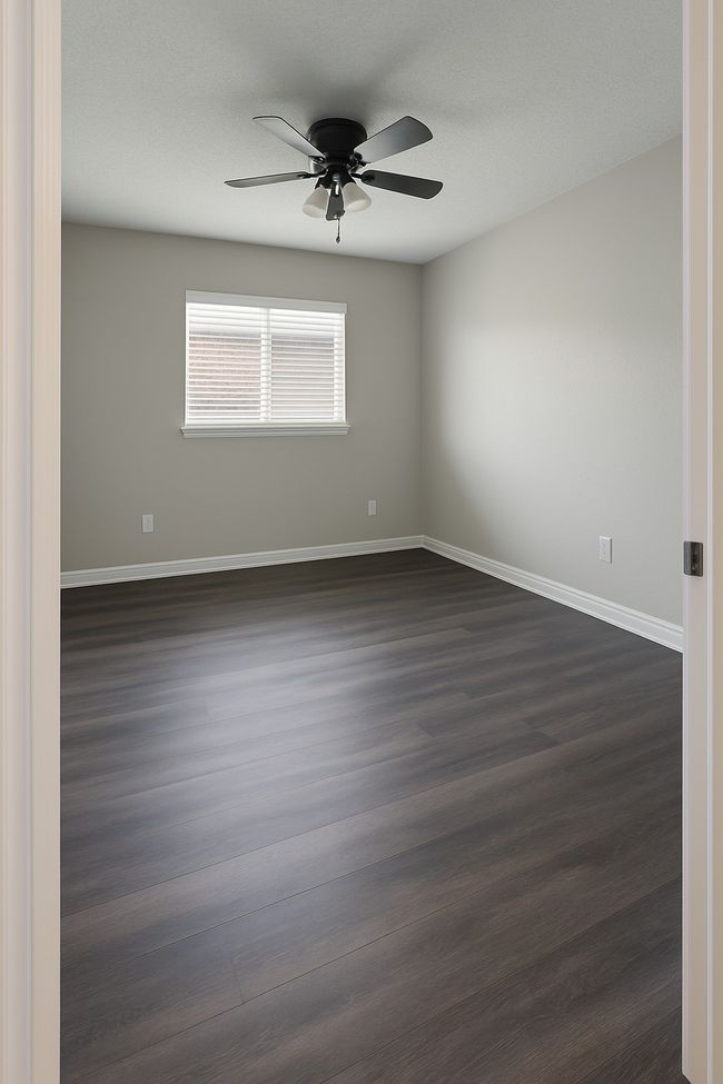 Empty room featuring a ceiling fan and dark wood finished floors | Image 8