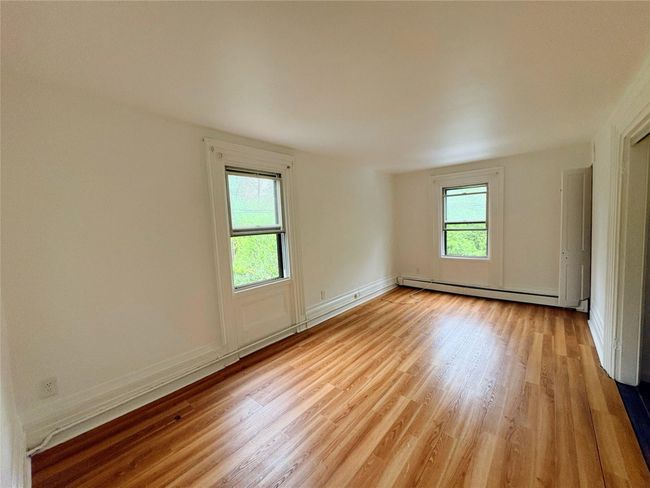 Empty room featuring baseboard heating, light wood-style flooring, and baseboards | Image 6