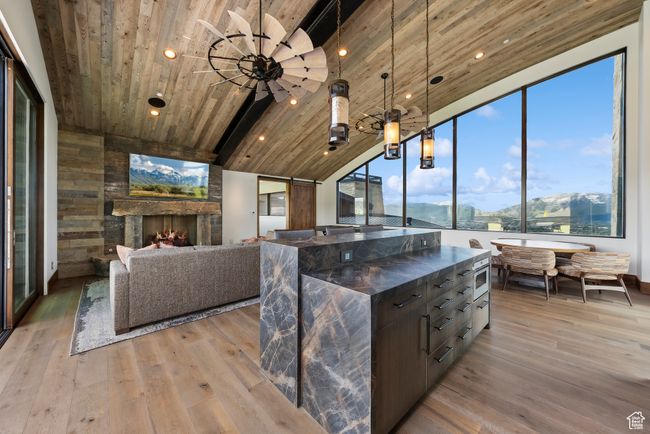 Kitchen featuring wood ceiling, light wood-style floors, lofted ceiling, a center island, and decorative light fixtures | Image 115