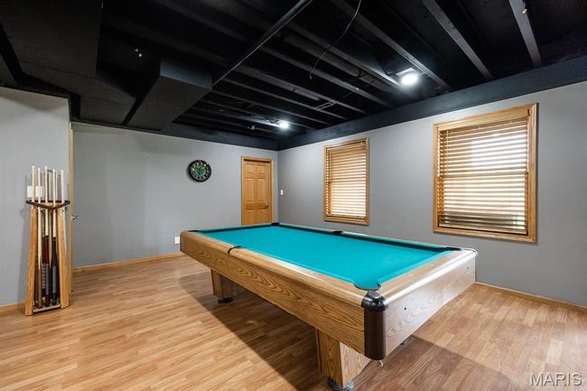 Game room with light wood-style floors, billiards table, and baseboards | Image 36