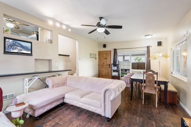 Living area featuring a ceiling fan, wood finished floors, and visible vents | Image 4