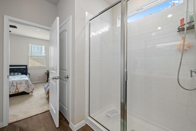 Bathroom with connected bathroom, a stall shower, wood finished floors, and baseboards | Image 16