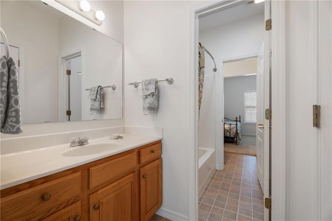 Full bath with vanity, a tub to relax in, tile patterned flooring, and a shower with curtain | Image 38