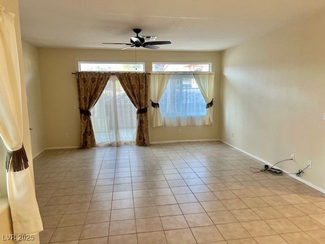 Spare room featuring light tile patterned floors, baseboards, and ceiling fan | Image 7