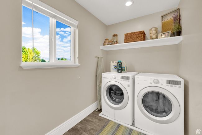 Laundry area featuring washing machine and clothes dryer, recessed lighting, and wood finished floors | Image 22