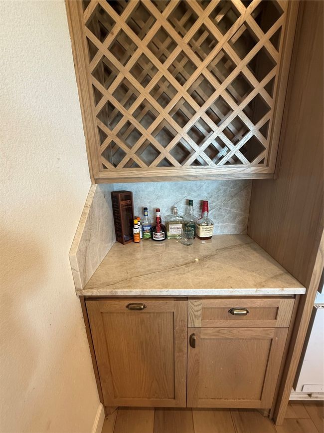 Indoor dry bar featuring tasteful backsplash and light wood-style floors | Image 21