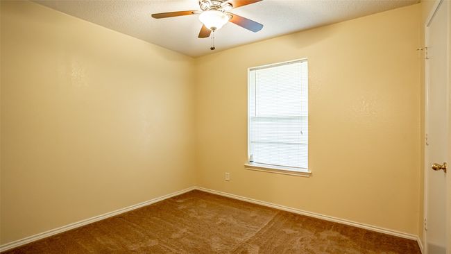 Carpeted spare room featuring ceiling fan and baseboards | Image 16