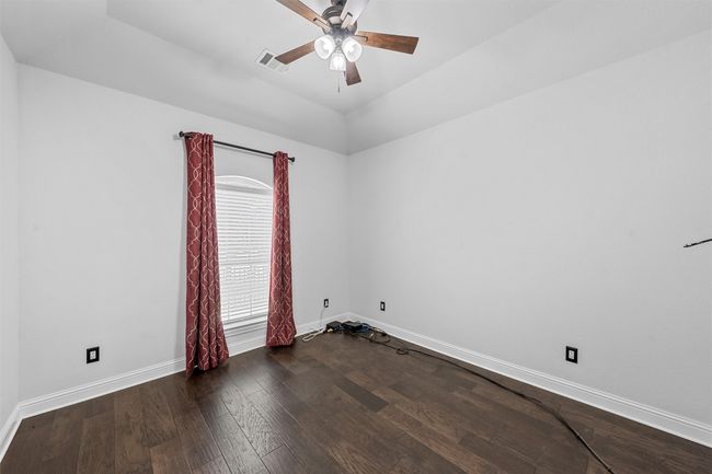 Unfurnished room featuring wood finished floors, ceiling fan, and lofted ceiling | Image 27