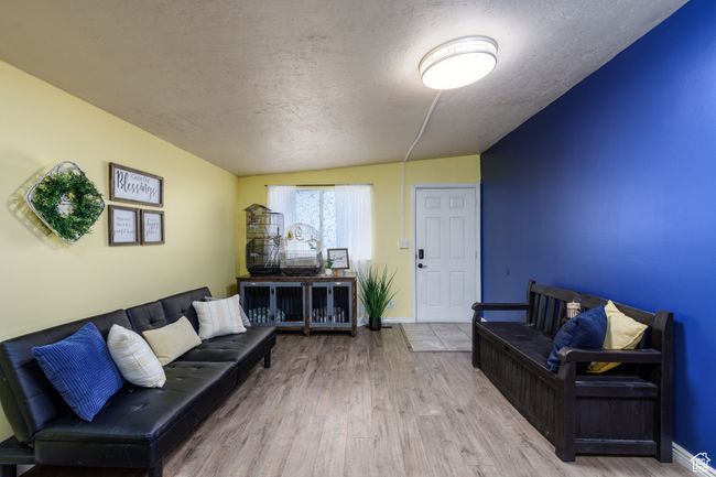 Living room with a textured ceiling and wood finished floors | Image 5