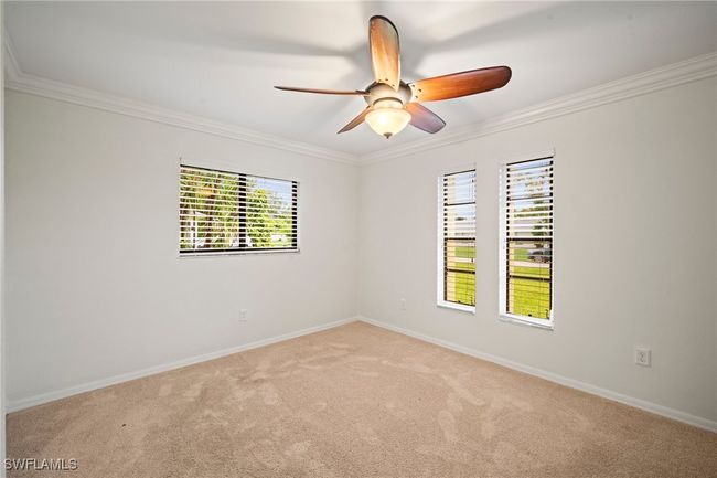 Spare room with crown molding, carpet, and a ceiling fan | Image 19