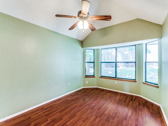 Spare room featuring vaulted ceiling, dark wood finished floors, and ceiling fan | Image 11