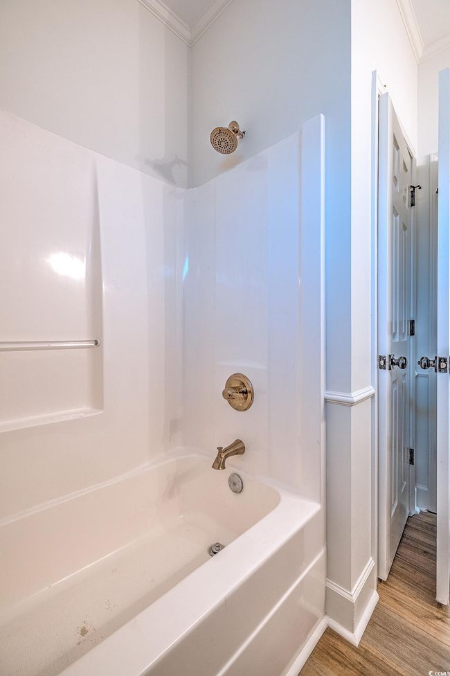 Bathroom with crown molding, wood finished floors, and shower / washtub combination | Image 18