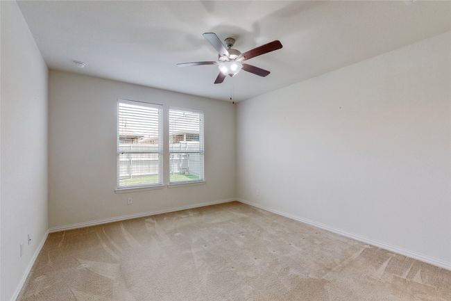 Unfurnished room featuring light carpet, a ceiling fan, baseboards, and a smoke detector | Image 19
