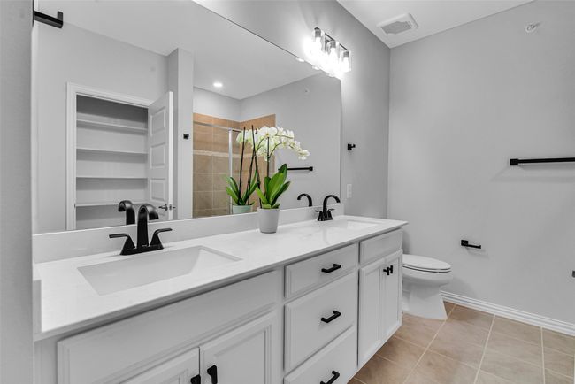 Bathroom with visible vents, a sink, a stall shower, and tile patterned flooring | Image 19