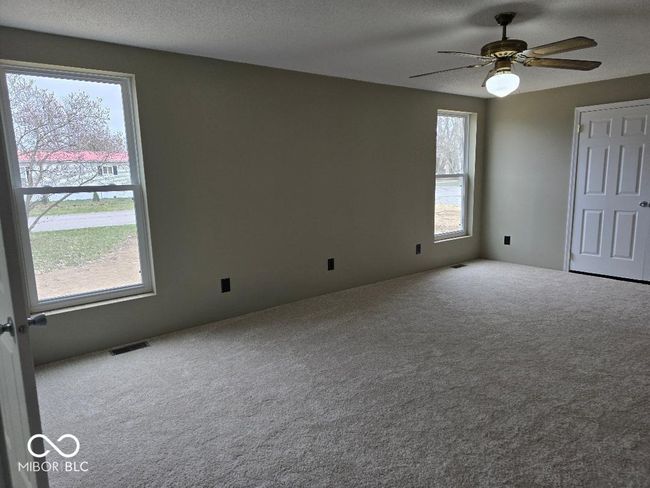 unfurnished bedroom with carpet flooring, ceiling fan, a textured ceiling, and visible vents | Image 23