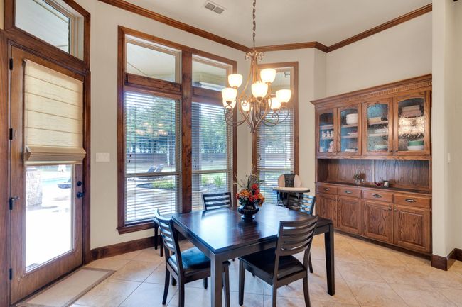 Breakfast area with built-in cabinets, a chandelier, light tile patterned floors, and ornamental molding | Image 19