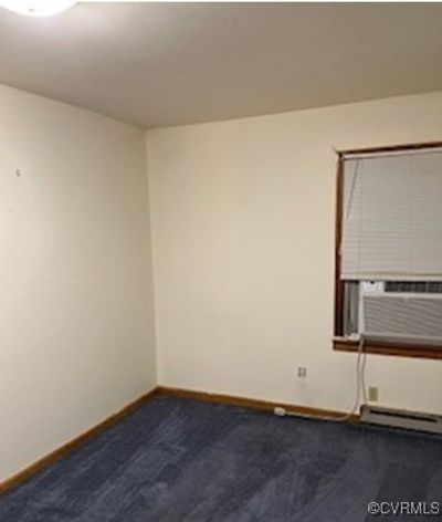 Spare room with carpet flooring, cooling unit, and a baseboard radiator | Image 2