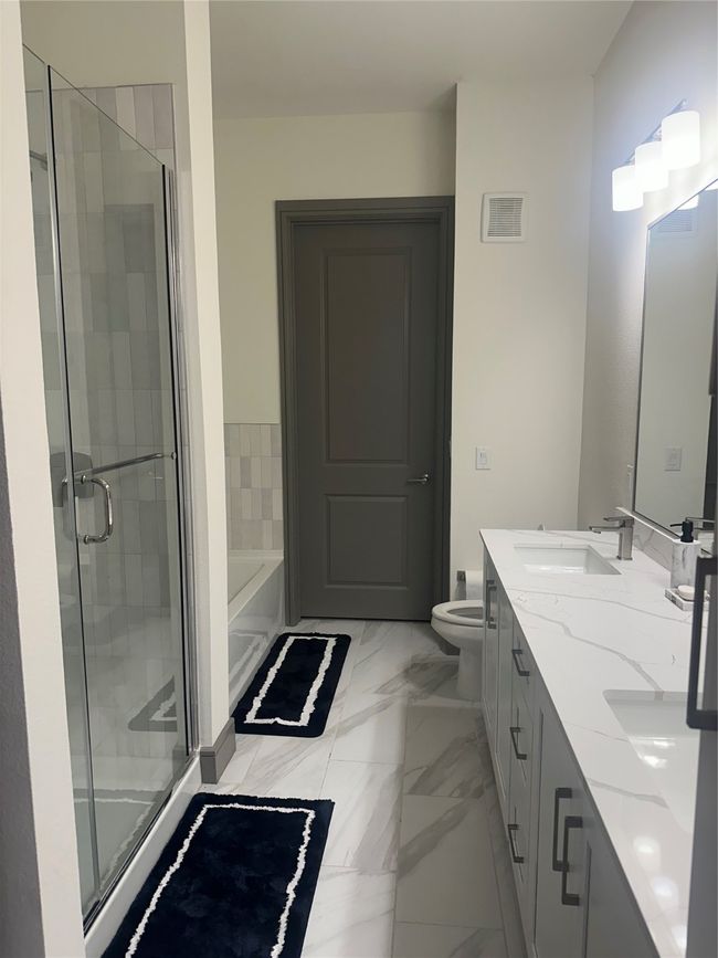 Bathroom with double vanity, a bath, a shower stall, and marble finish floors | Image 5