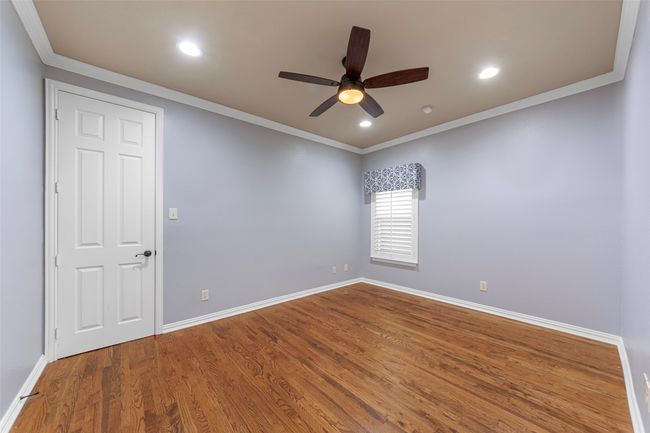 Empty room with ceiling fan, baseboards, crown molding, wood finished floors, and recessed lighting | Image 28