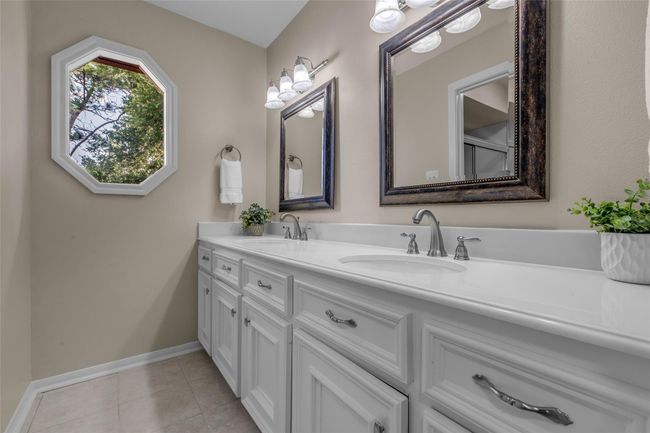 Upstairs bathroom with double sinks, bright lighting and separate room with shower/tub combo and toilet. Additional storage and built in cabinets. | Image 31