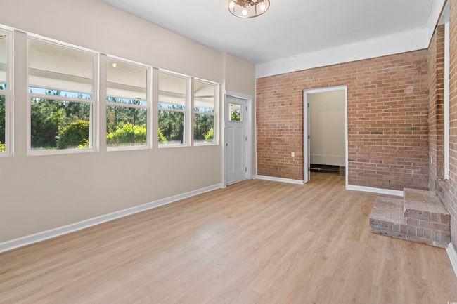 Unfurnished room with brick wall and light wood-type flooring | Image 10