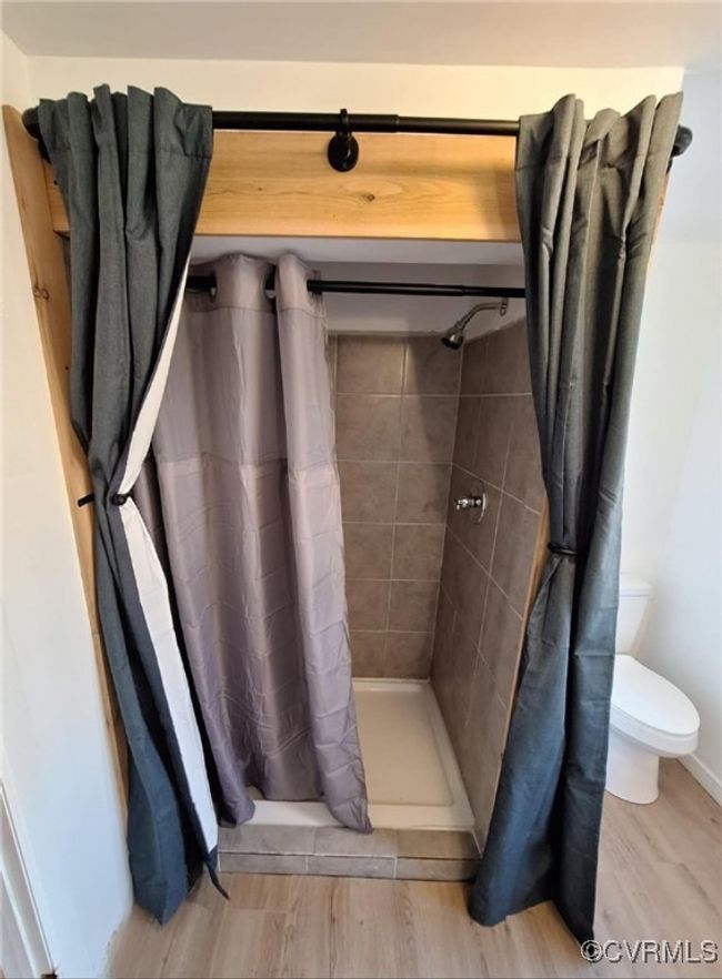 Full bathroom featuring toilet, wood finished floors, and a shower stall | Image 34