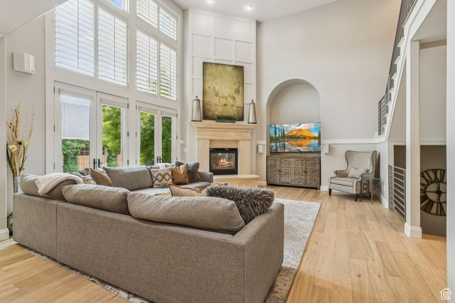 Living room with a high ceiling, a fireplace, plenty of natural light, and light wood-style flooring | Image 11