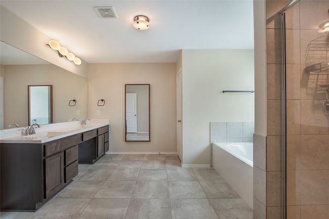 Bathroom with a bath, double vanity, and tiled shower | Image 24