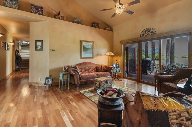 Living room featuring hardwood / wood-style flooring, a ceiling fan, stairs, and high vaulted ceiling | Image 29
