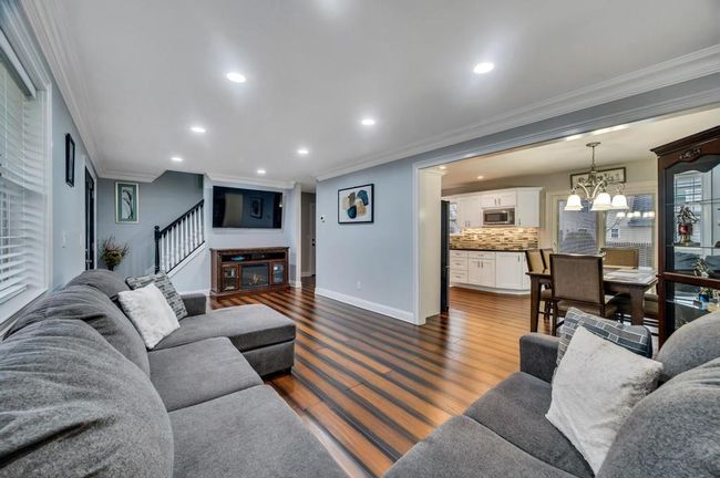 Living area with recessed lighting, ornamental molding, a chandelier, and dark wood finished floors | Image 9