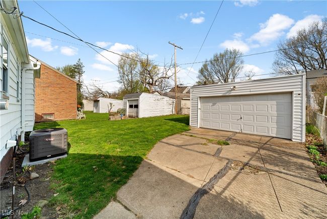 View of yard featuring an outdoor structure, central AC, and a garage | Image 30
