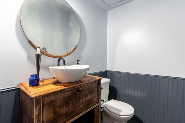 Bathroom with vanity, toilet, and a wainscoted wall | Image 19