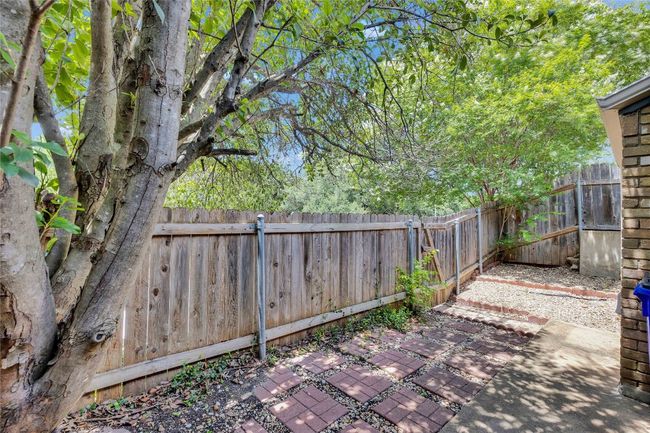 Fenced backyard with a patio area | Image 25