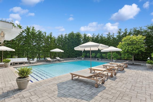 Swimming pool featuring a patio area and view of wooded area | Image 25